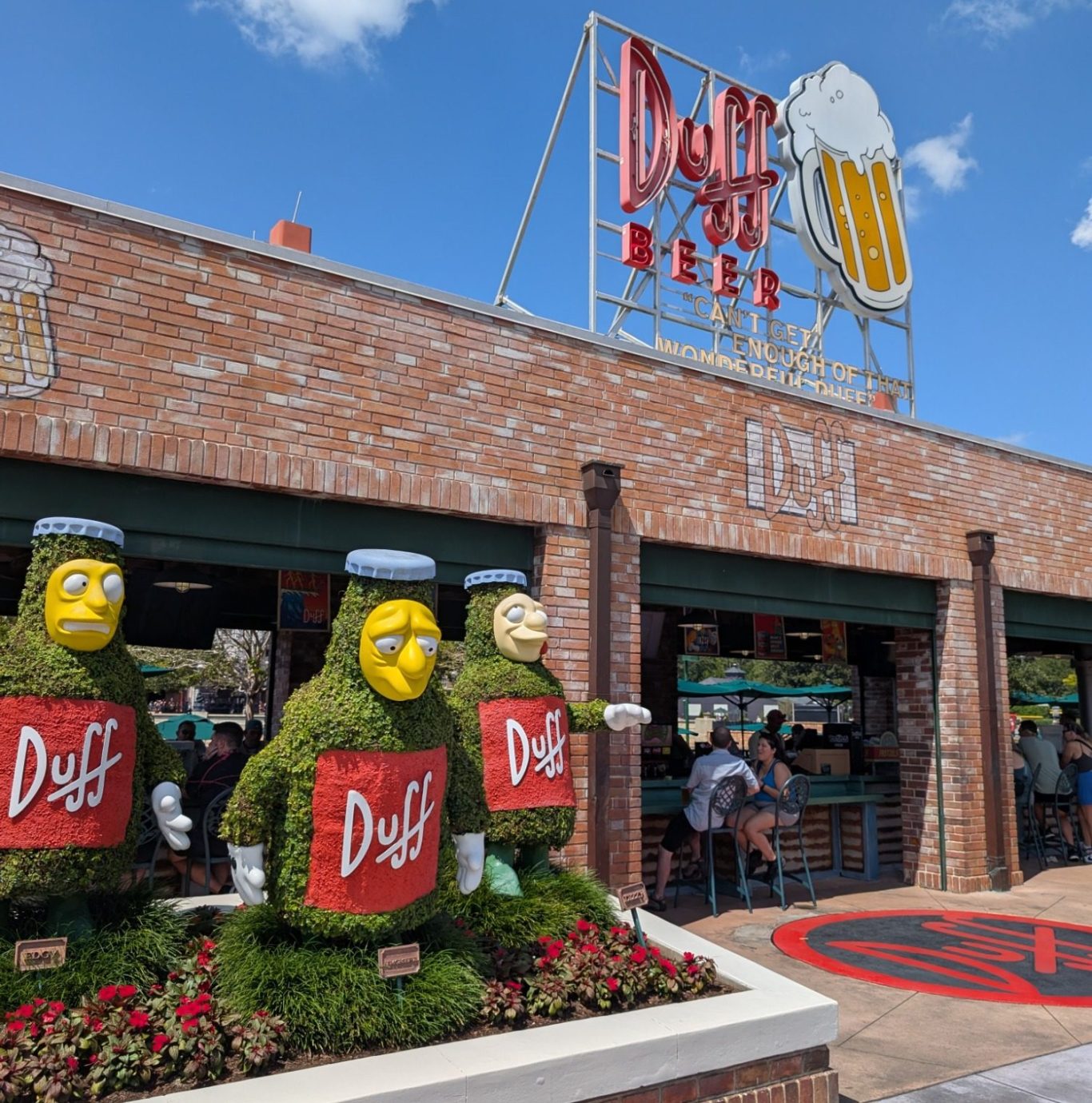 Duff Beer restaurant with topiary characters and a large beer sign.