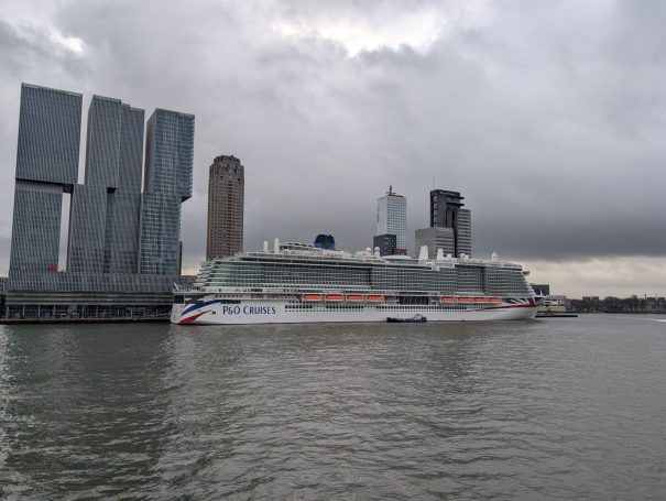 P&O Iona cruise ship docked in Rotterdam under a cloudy sky.
