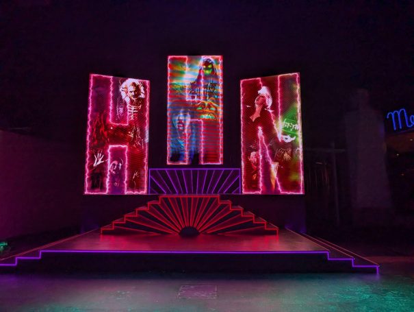 Brightly lit letters "H H N" displayed on a stage with colourful neon effects at Halloween Horror Nights at Universal Studios, Singapore.