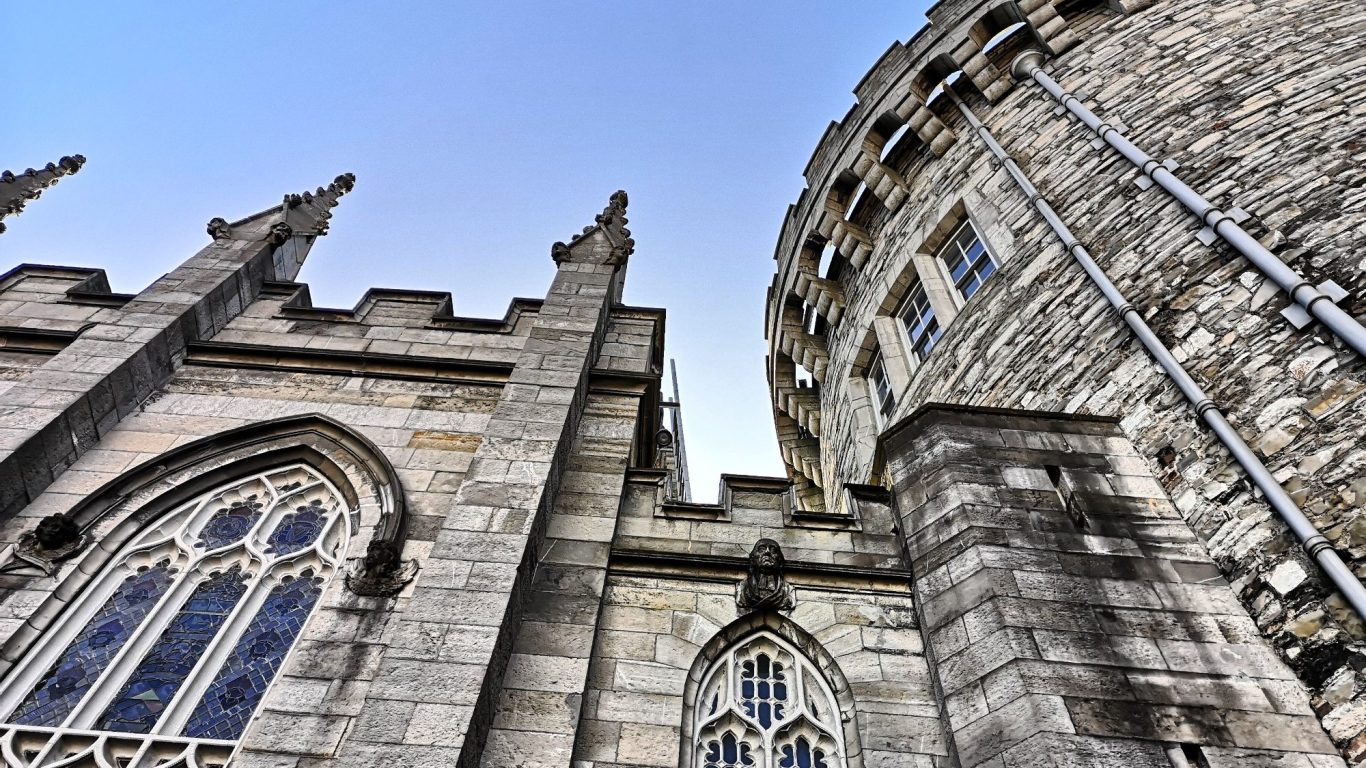 Historic Dublin Castle featuring a gothic-style church and a cylindrical tower.