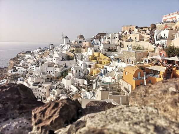 White buildings with blue domes on hills overlooking the sea in Santorini, Greece.