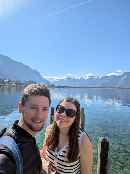 I&B Founder & Husband posing in front of Lake Geneva with mountains in the background.