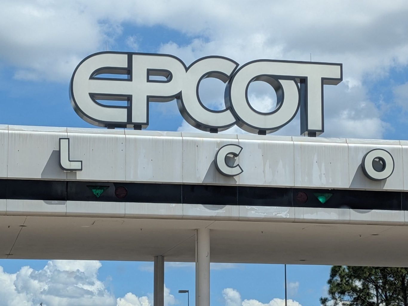 Sign for the EPCOT theme park entrance against a cloudy sky.