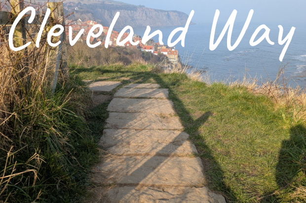 Pathway of the Cleveland Way with coastal views of Robin Hood's bay and grass on either side.