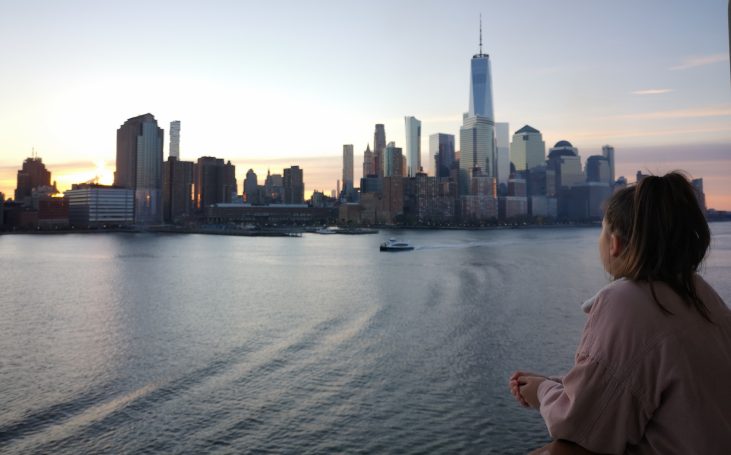I&B's Founder looking at the New York City skyline during sunrise with Hudson River in the foreground.