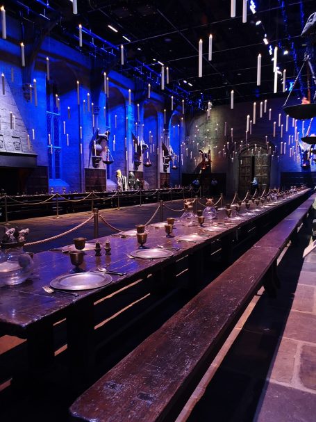 A long table with several goblets set in a dimly lit, themed room. Located in The Great Hall, at Warner Bros Studio Tour.