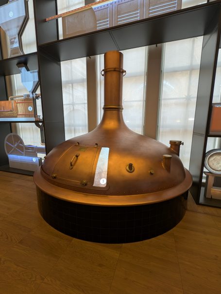 Copper brewing vessel displayed in a modern interior.