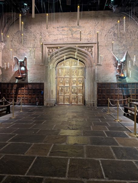 Wooden double doors of the great hall decorative wall features and overhead lighting at Warner Bros studio tour London