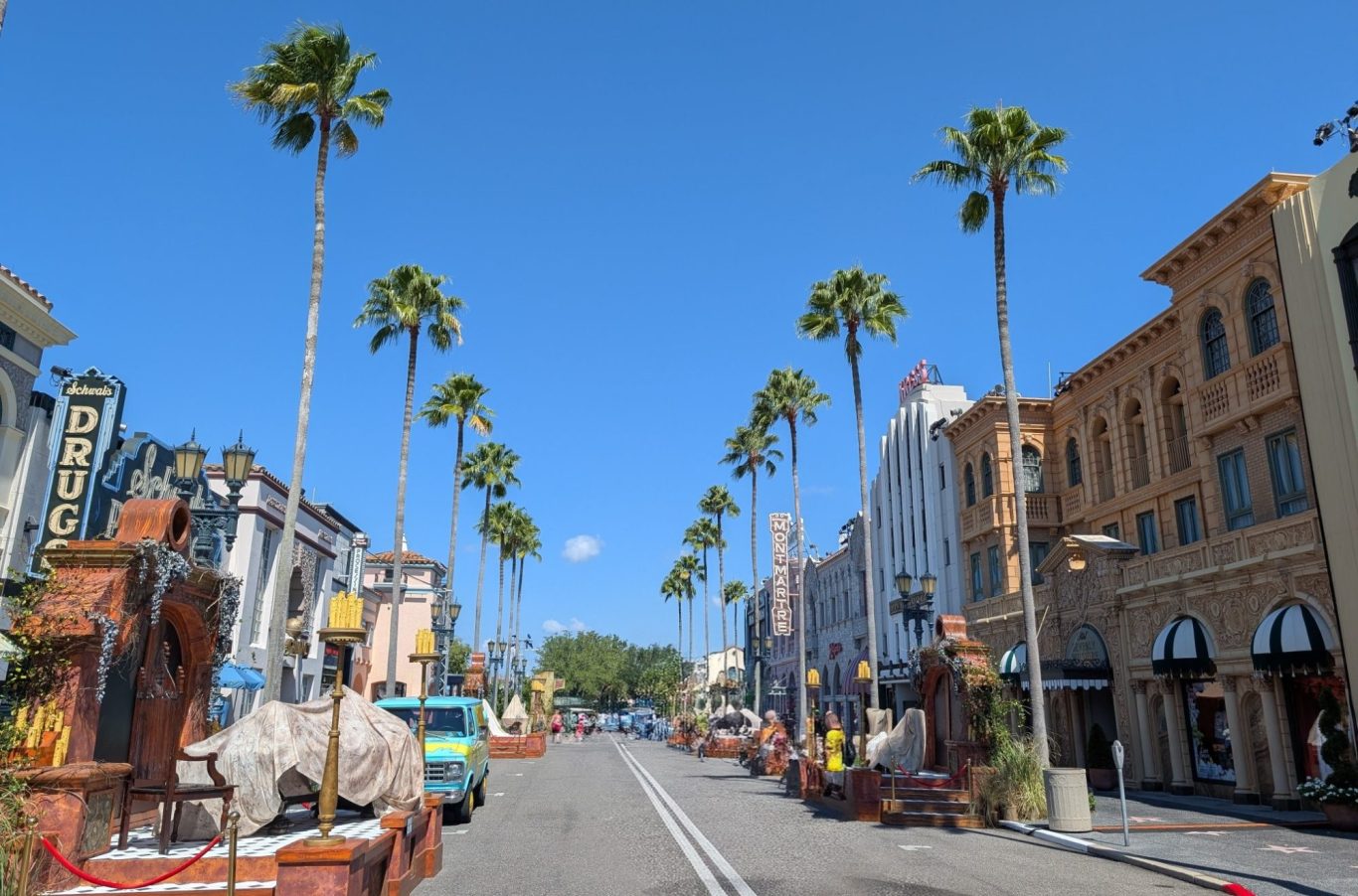 A sunny street lined with palm trees and buildings in a festive atmosphere.
