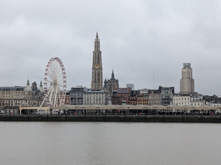 Panoramic view of Antwerp’s skyline featuring a ferris wheel and historic buildings.