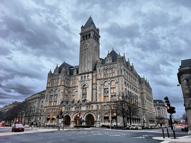 Old Post Office building with a tall clock tower, set against a cloudy sky in Washington DC.