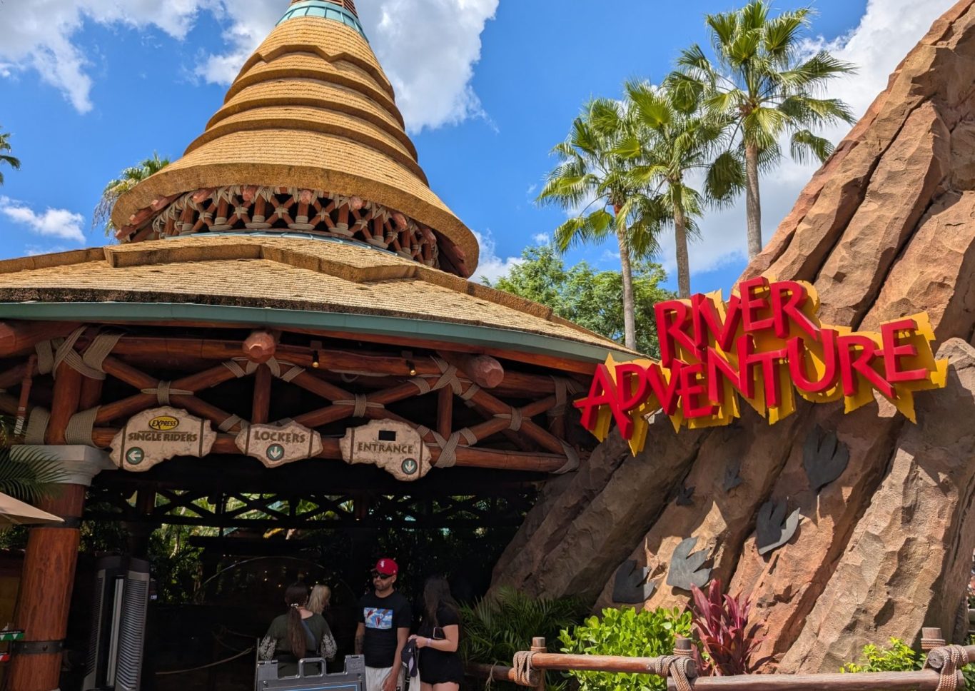 Entrance to the River Adventure ride, featuring a large rock formation and tropical decor.