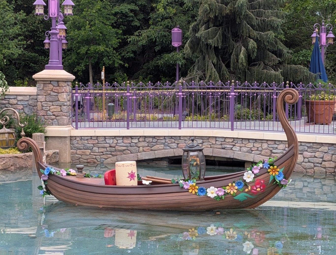 A decorative boat with floral decorations floating in a tranquil water setting.