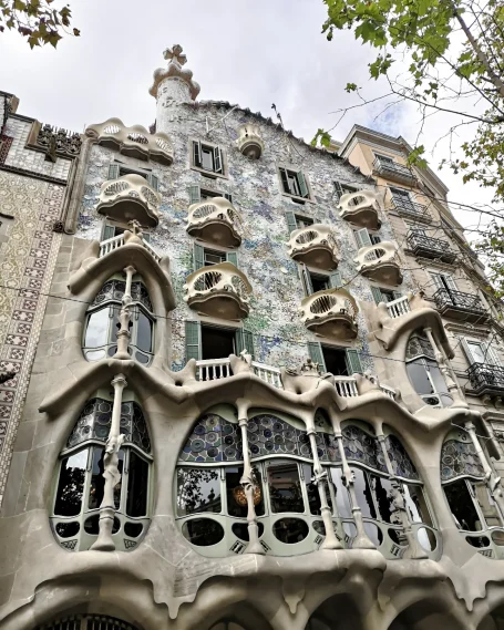 Decorative façade of Casa Batlló in Barcelona, featuring organic shapes and colourful mosaics.