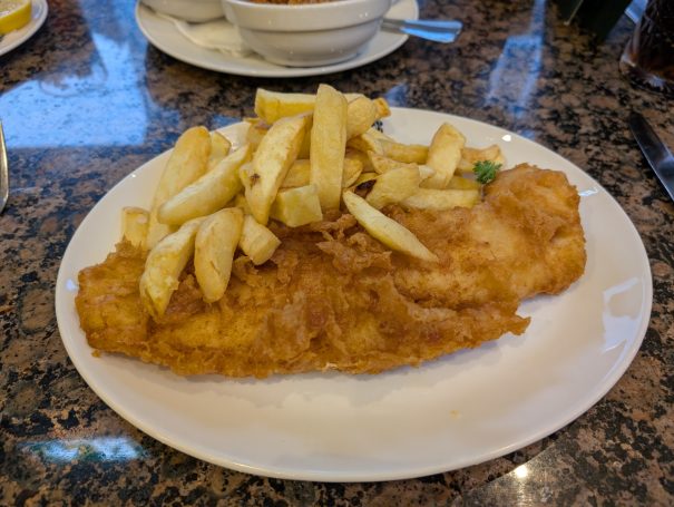 A plate of fish and chips with crispy battered fish and thick-cut chips. This is the offering at Trenchers in Whitby.