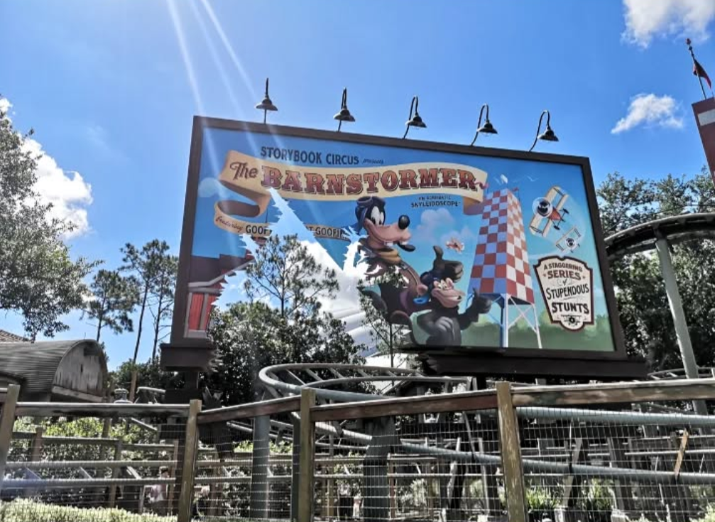 Billboard advertising a theme park ride featuring cartoon characters and playful graphics.