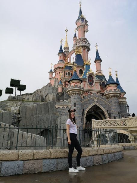 I&B's Founder posing in front of the pink princess castle at Disneyland Paris
