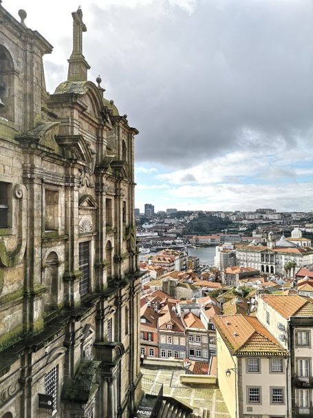 View of a historical building overlooking the Porto cityscape with cloudy skies.