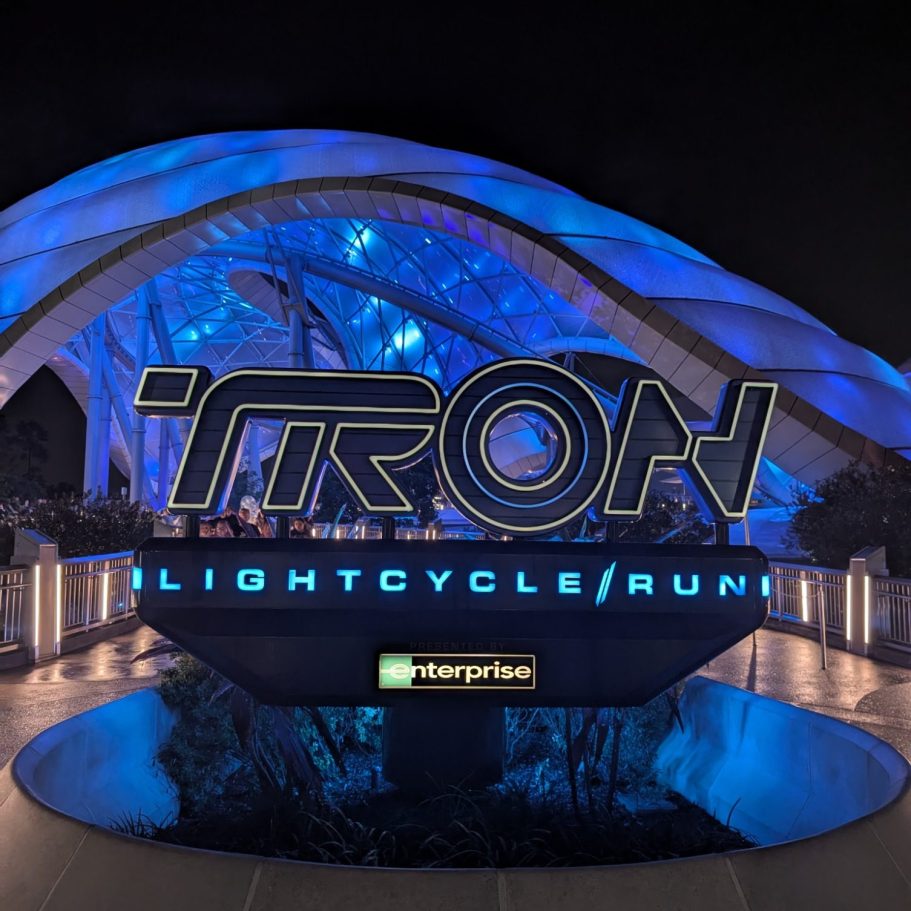 Signage for 'TRON Lightcycle Run' featuring blue lighting and futuristic design.