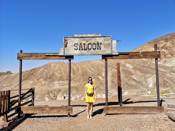 I&B's Founder standing in front of a rustic saloon sign in a desert landscape, located at Calico Ghost Town in California.