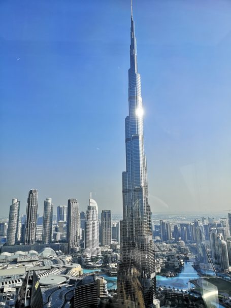 Burj Khalifa towering over a modern city skyline under a clear blue sky.