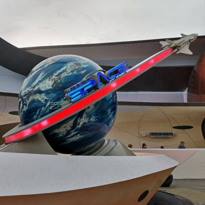 A globe with a red ribbon and an aircraft model, representing space exploration.