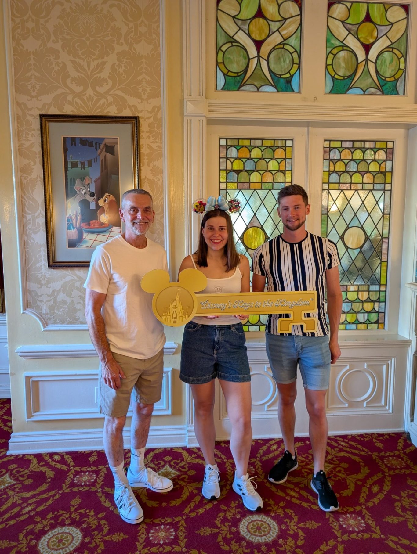 I&B's Founder, Husband & Dad posing with the Keys to the Kingdom large gold key before the tour at Magic Kingdom.