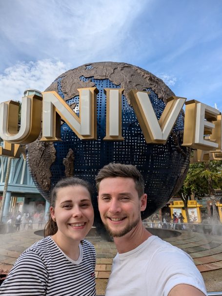 I&B's Founder & Husband posing in front of the giant Universal globe outside of Universal Studios, Singapore