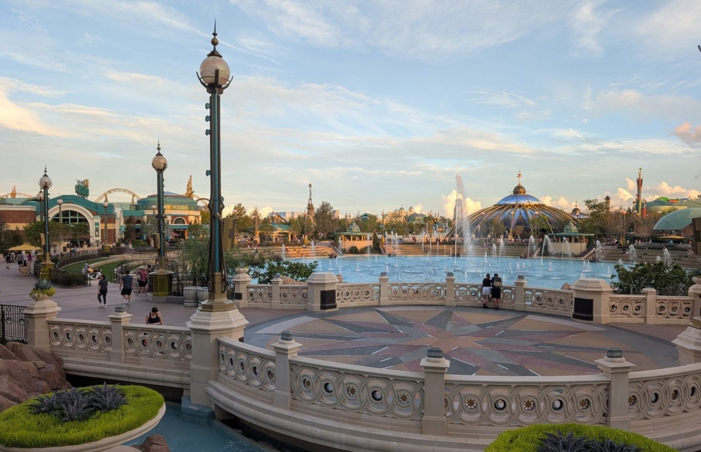 A scenic view of a park with fountains, pathways, and decorative architecture.
