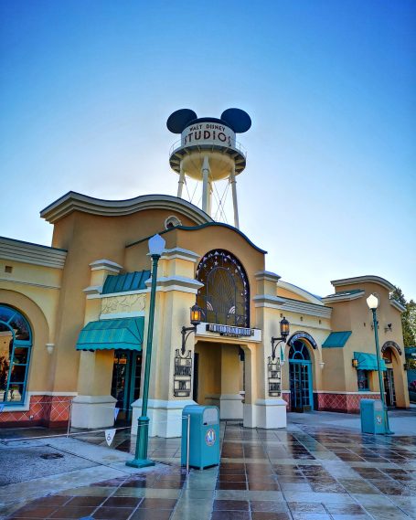 Building facade featuring Mickey Mouse ears atop a water tower against a clear blue sky.