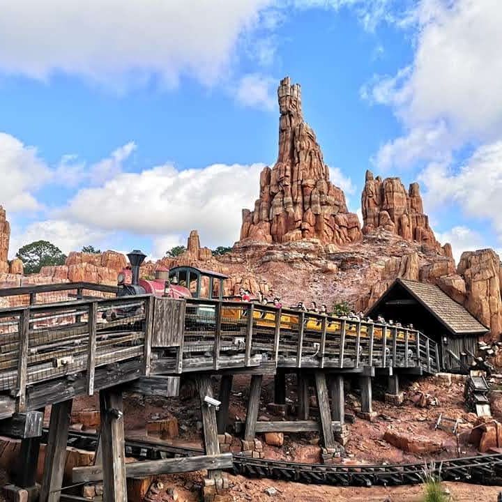 Rustic wooden walkway leads to a mountainous backdrop, reminiscent of a Wild West landscape.