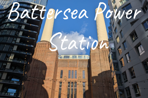 Battersea Power Station with two iconic chimneys against a blue sky.