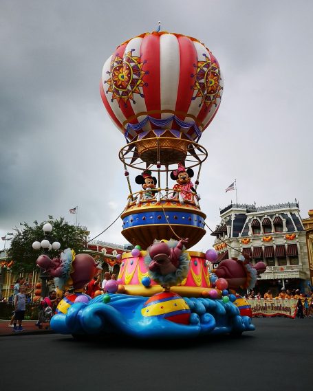 A vibrant parade float featuring a hot air balloon with characters and colourful decorations.