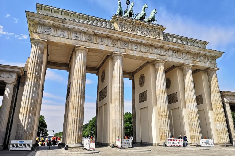 The Brandenburg Gate in Berlin with tall columns under a clear blue sky.