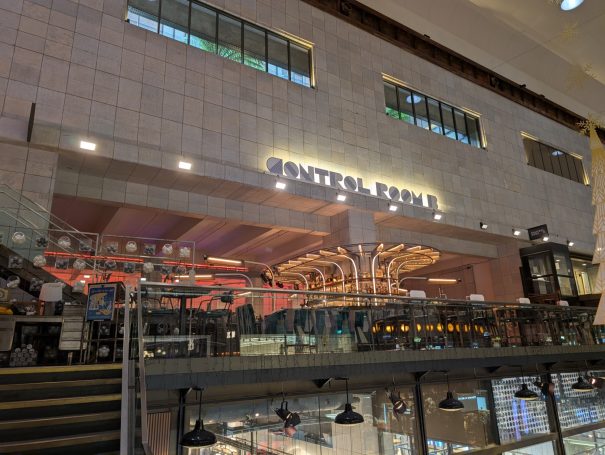 Modern restaurant interior with colourful lighting and seating arrangements.