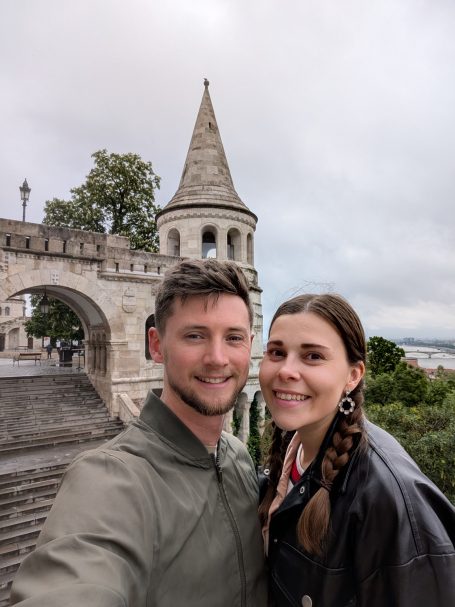 I&B's Founder & Husband posing in front of the tower of Fisherman's Bastion in Budapest