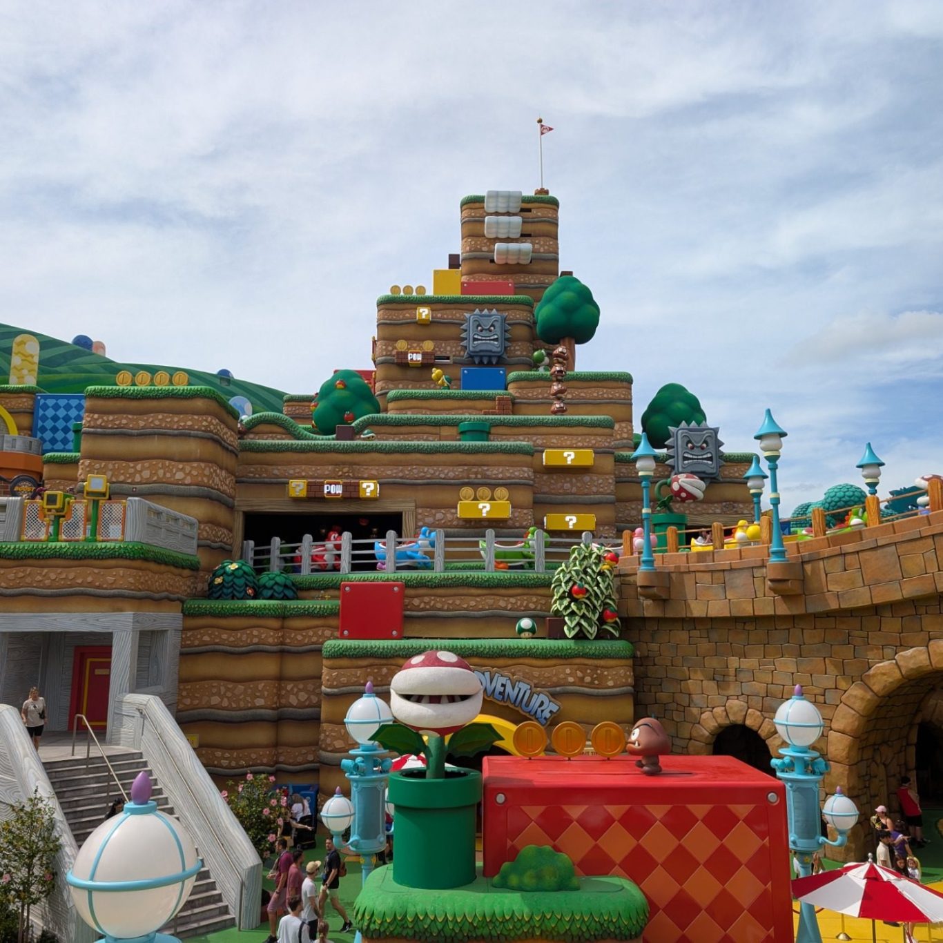 Colourful amusement park featuring a themed Mario world with hills, trees, and playful structures.