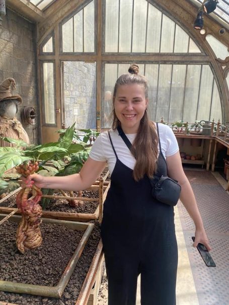 I&B's Founder posing in a greenhouse at Warner Bros Studio Tour, pulling a mandrake from the soil.