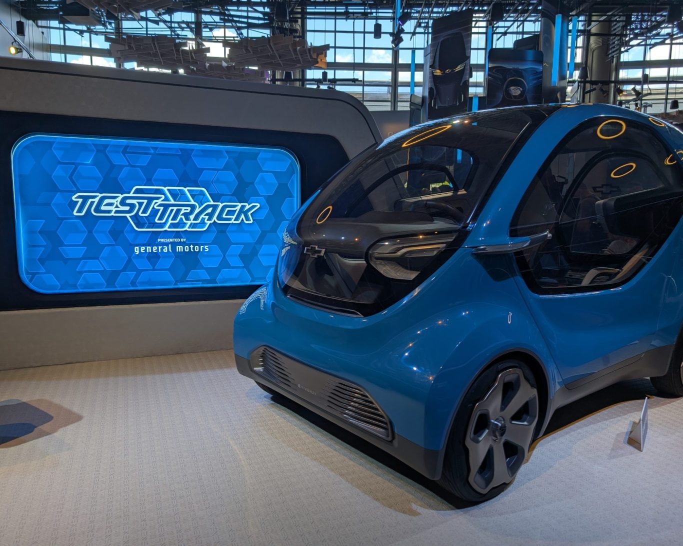 Futuristic blue autonomous vehicle displayed at a technology exhibition.