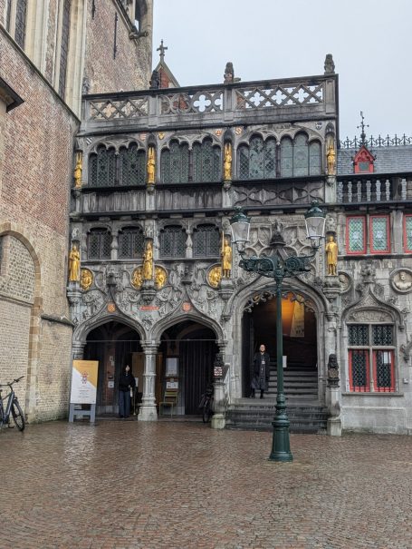 Historic Basilica of the Holy Blood building with ornate façade, arched entrance, and decorative wooden details.