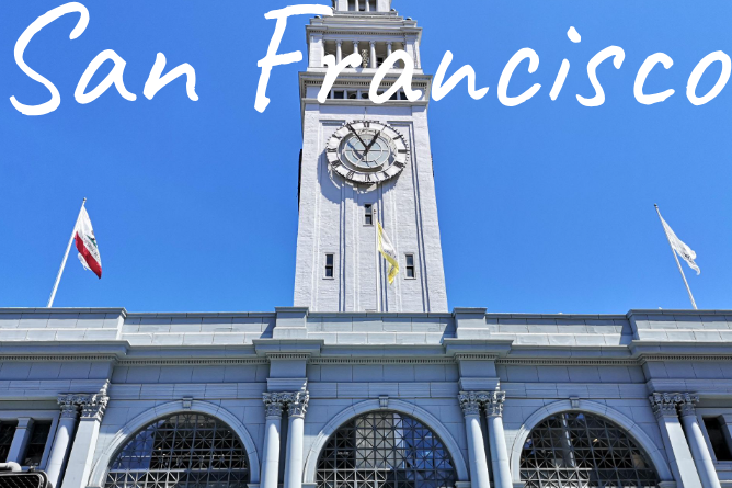 Clock tower of the Ferry Building in San Francisco against a clear blue sky.