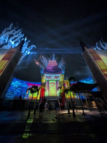 Colourful illuminated temple at night with dramatic lighting and reflections.