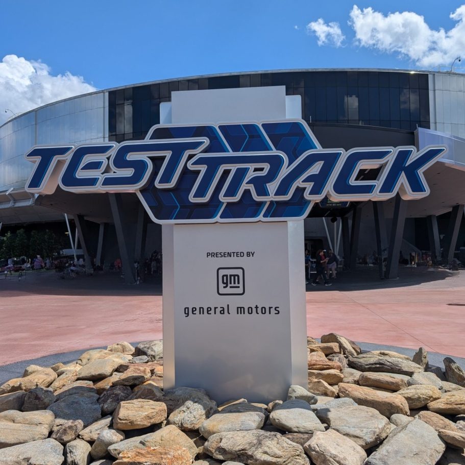 Sign for Test Track at a theme park, featuring a modern design and rocky base.