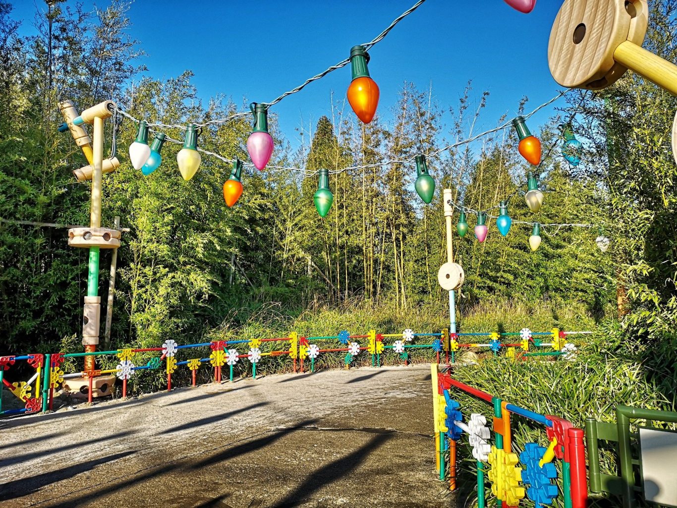 Colourful outdoor play area with decorative lights and surrounding trees.