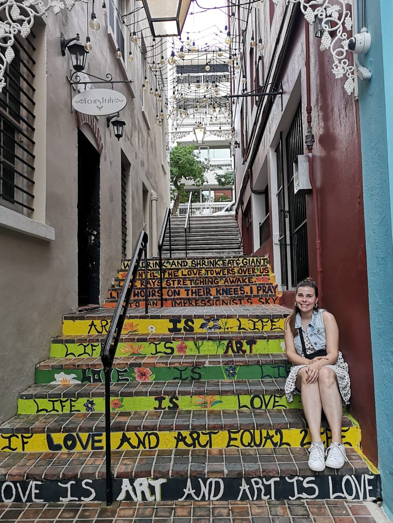 I&B's Founder posing on the colourful Chancery Lane stairs in Hamilton, Bermuda.
