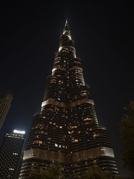 Burj Khalifa towering against a night sky, illuminated by city lights.