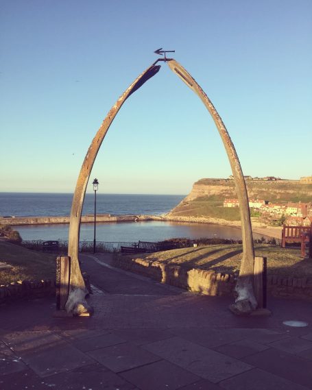 A large whale bone archway overlooking a coastal view.