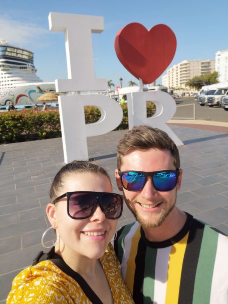 I&B's Founder & Husband posing in front of the I Heart PR Sign in San Juan