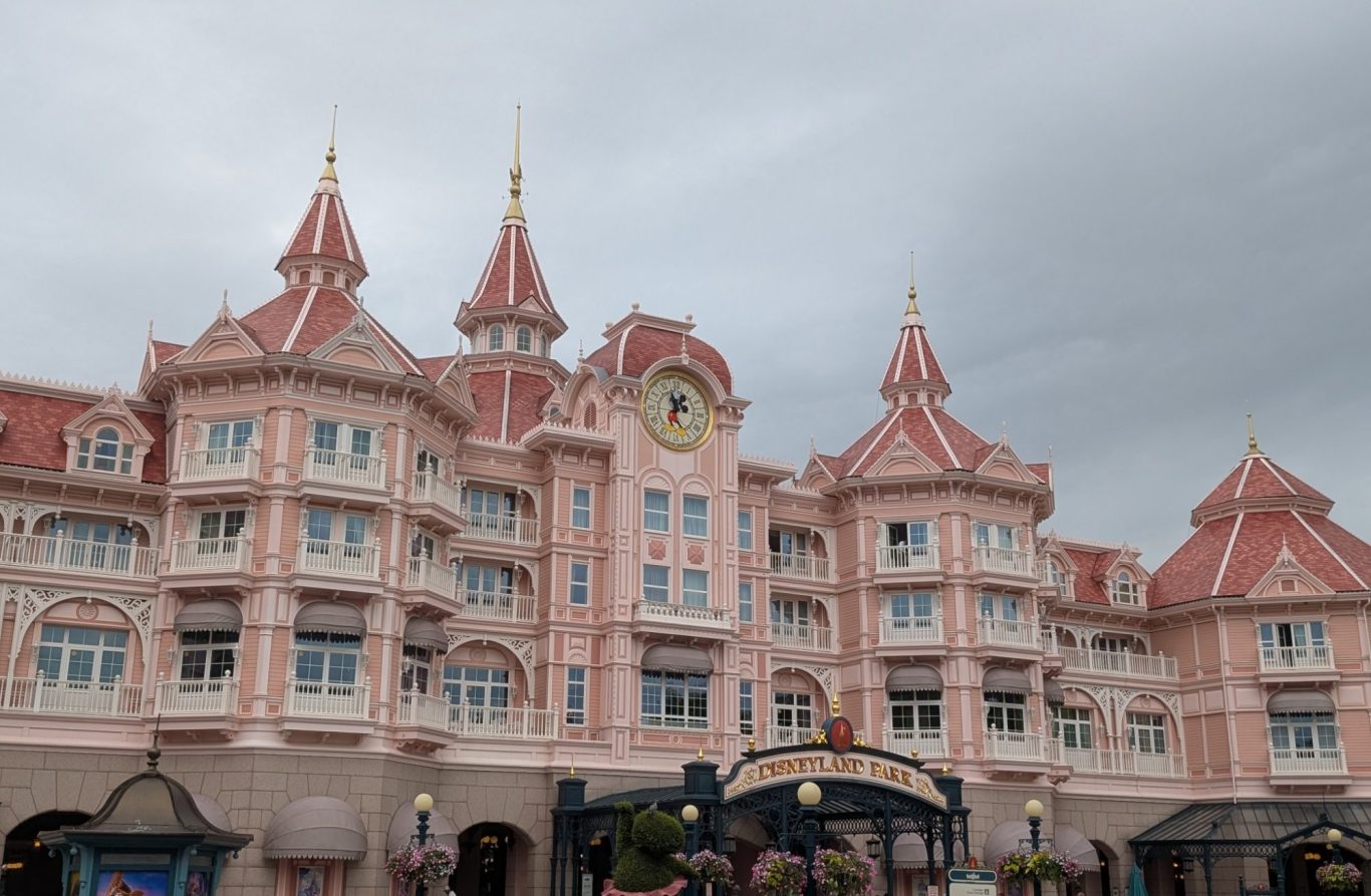 A grand pink hotel with turrets and ornate details under a cloudy sky.
