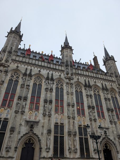City Hall building with intricate details and tall spires against a grey sky.